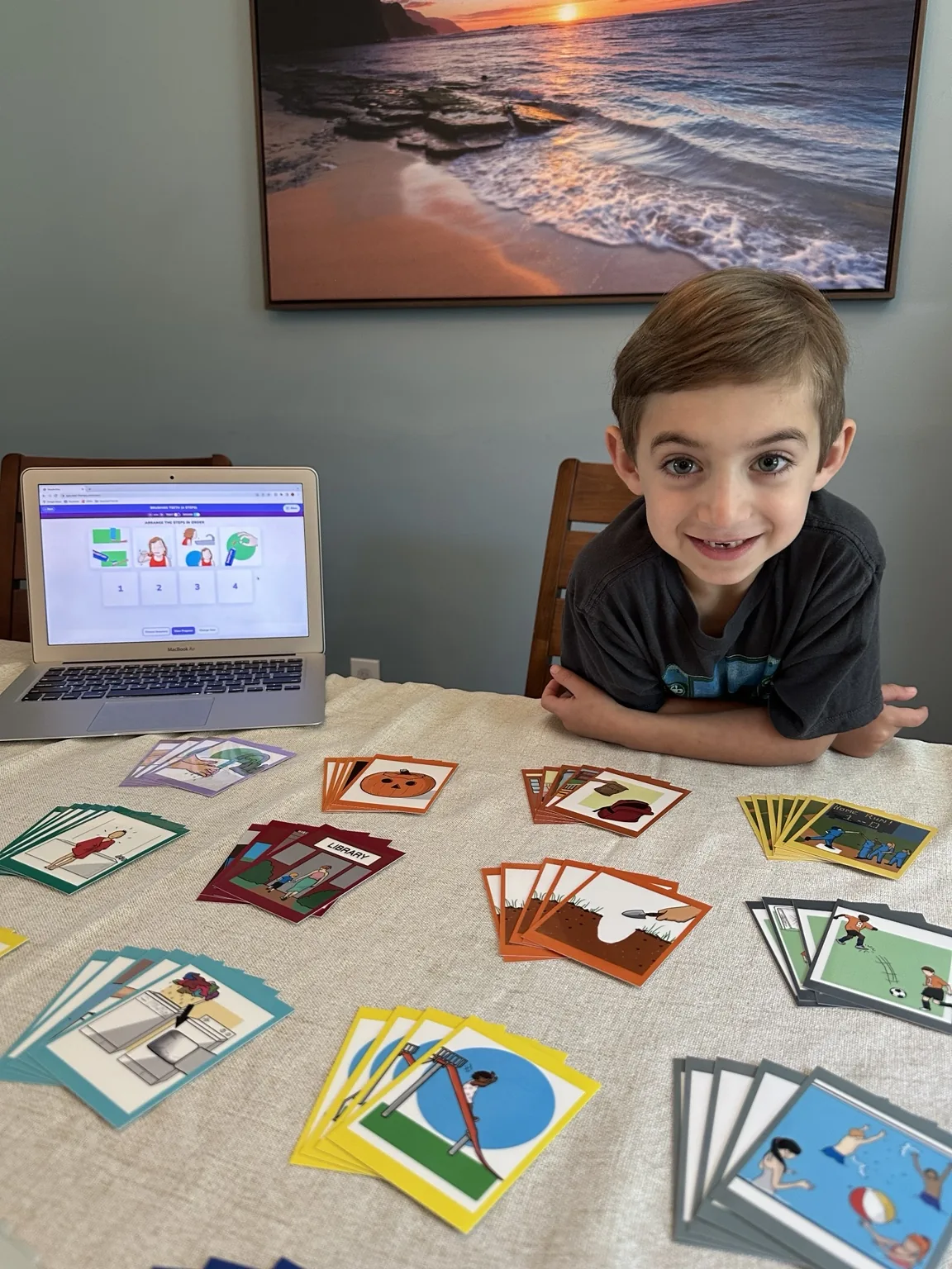 Child using StepByStep laminated sequence cards alongside the digital app